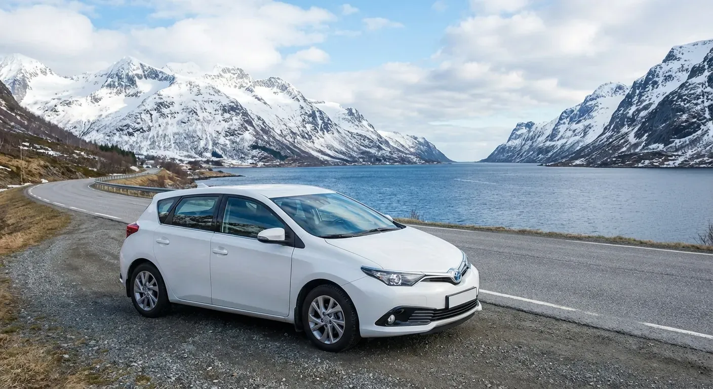 Et oversiktsbilde av en moderne undervisningsbil parkert ved en kystvei med fjell i bakgrunnen