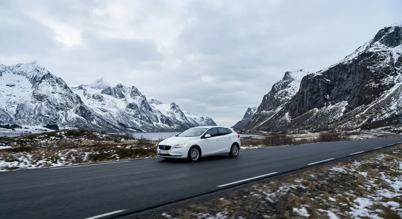 En moderne undervisningsbil som kjører rolig på en vei omkranset av fjell i Tromsø